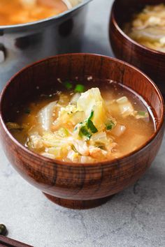 two wooden bowls filled with soup on top of a table