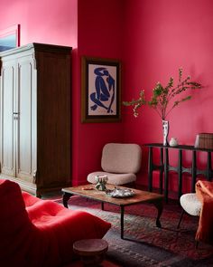 a living room with red walls and furniture