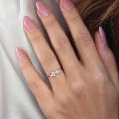 a woman's hand with pink manicured nails and a ring on her finger