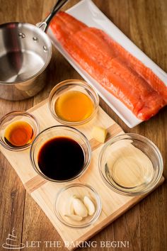 the ingredients to make this dish are displayed on a cutting board, including fish and sauces