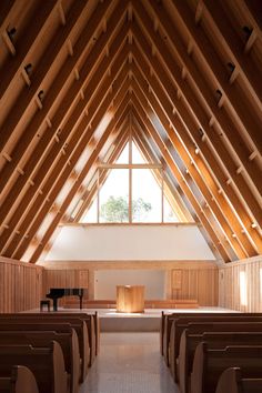 an empty church with wooden pews and a grand piano