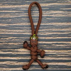 a stuffed animal hanging from a rope on a wooden surface