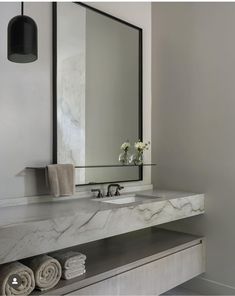 a bathroom vanity with marble counter top and mirror