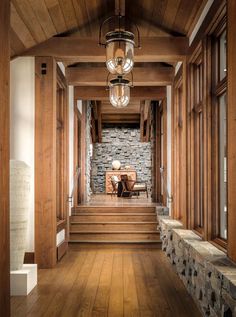 a wooden hallway with stone walls and wood steps leading up to the second floor area