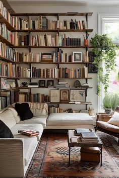 a living room filled with lots of furniture and bookshelves full of books on the wall