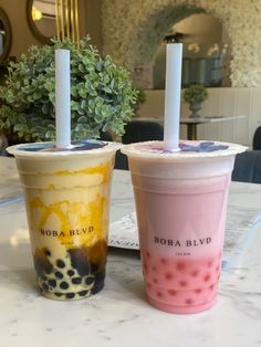 two bubble teas sitting on top of a table