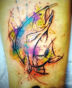 a colorful fish tattoo on the thigh