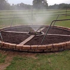 a fire hydrant spewing out water on top of a circle shaped garden