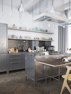 an industrial kitchen with stainless steel appliances and wood flooring is pictured in this image