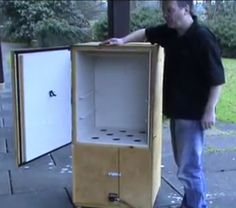 a man is standing next to two empty cabinets