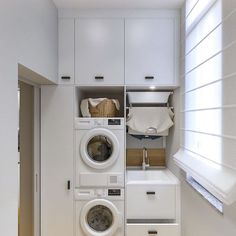 a washer and dryer in a small room with white cabinets on the wall