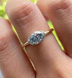 a woman's hand with a ring on it that has a blue diamond in the middle