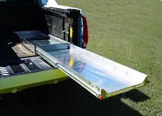 the back end of a yellow truck with its flatbed open and sliding door opened