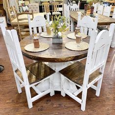 a wooden table with white chairs around it in a room filled with tables and chairs