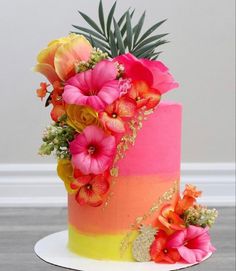 a multi - colored cake decorated with flowers and succulents