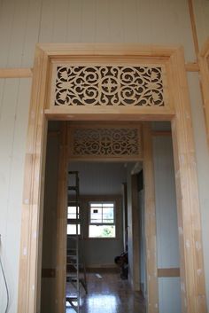 an open door leading into a room with white walls and wood trimming on the ceiling