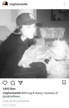 a woman sitting on top of a couch next to a white dog wearing a hat