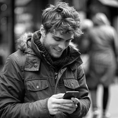 a man looking at his cell phone while walking down the street