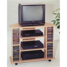 a television sitting on top of a wooden shelf filled with dvd's and video equipment