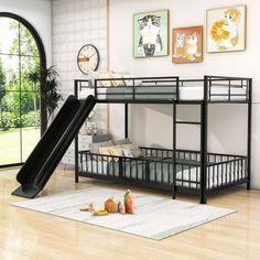 a black bunk bed with a slide in the middle and pictures on the wall behind it