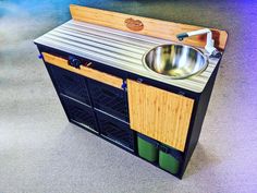 a kitchen sink made out of an old metal cabinet with wood paneling on the sides