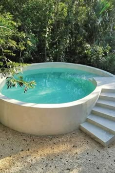 an outdoor swimming pool with steps leading up to it and trees in the back ground