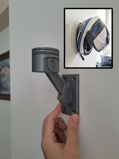 a hand is holding the door handle on a wall with a camera attached to it