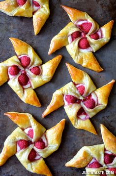 small pastries with raspberries are arranged on a baking sheet, ready to be eaten