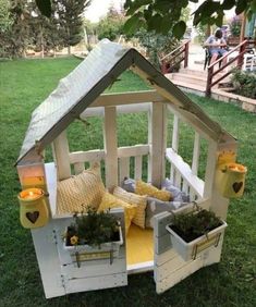 a doll house made out of wooden pallets with potted plants in the middle