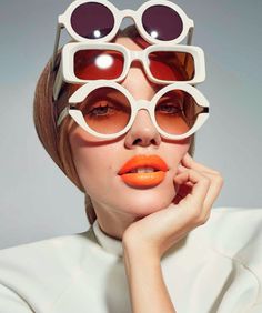 a woman with orange lipstick and sunglasses on her face