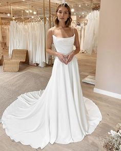 a woman standing in front of a white dress