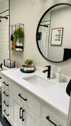 a bathroom with black and white tile flooring, a mirror above the sink and a toilet