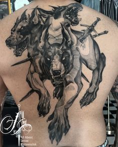 the back of a man's body with tattoos on it and an image of two horses