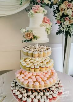 a three tiered cake with cupcakes on it