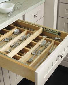 an open drawer with silverware in it