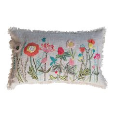 an embroidered pillow with colorful flowers on the front and fringe trimmings around the edges