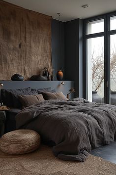 a large bed sitting in a bedroom next to a window with lots of pillows on top of it