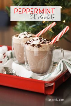 two glasses of peppermint hot chocolate on a red tray with candy canes