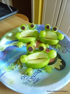 a plate that has some fruit on it with frog faces and eyes sitting on top of each other