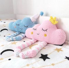 two crocheted stuffed animals laying on top of a bed next to each other