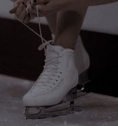 a person tying their shoelaces while sitting on a skateboard