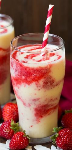 two glasses filled with strawberries on top of a table