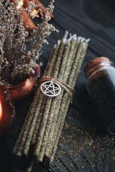 an image of some sticks with pentagrams on them next to flowers and candles