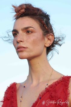 a woman with freckled hair wearing a red dress