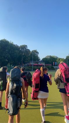 several people with backpacks are walking on the tennis court and one person is looking at her cell phone