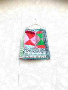 a colorful patchwork skirt hanging on a wall