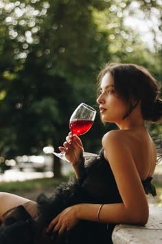 a woman sitting on a bench holding a glass of wine