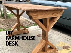 a wooden table sitting on top of a sidewalk next to a blue car with the words diy farmhouse desk written below it