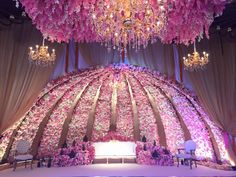 the stage is decorated with pink flowers and chandelier hanging from it's ceiling