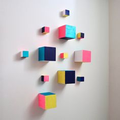 colorful cubes are arranged on a white wall